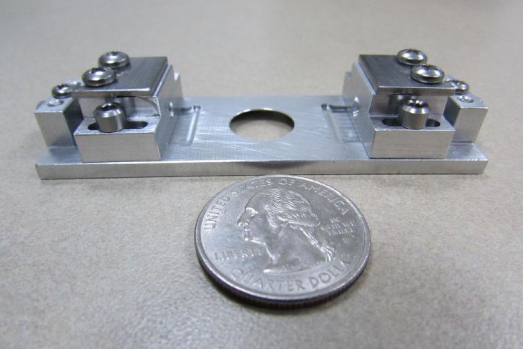 Custom titanium mini dual slider alongside a quarter for scale