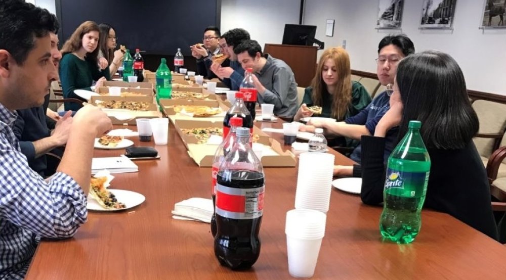 People sit at a conference table eating lunch