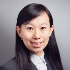 Person with long dark hair and grey jacket