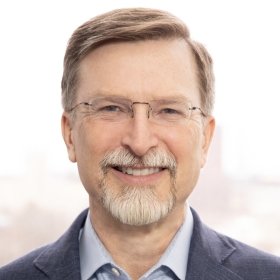 Smiling person with glasses and beard