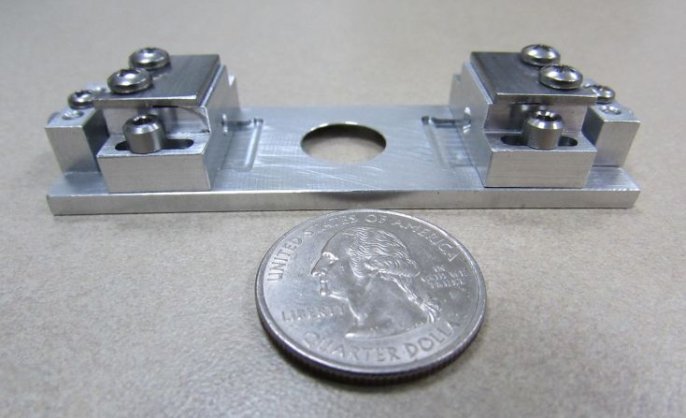 Custom titanium mini dual slider alongside a quarter for scale