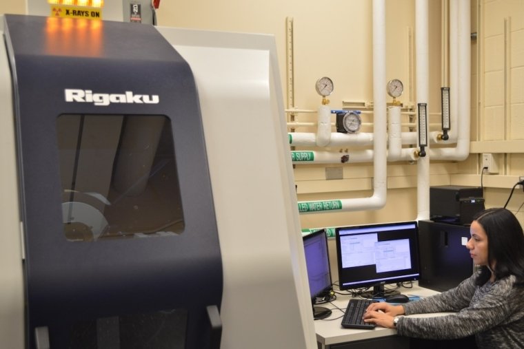Scientist at workstation beside X-ray diffractometer